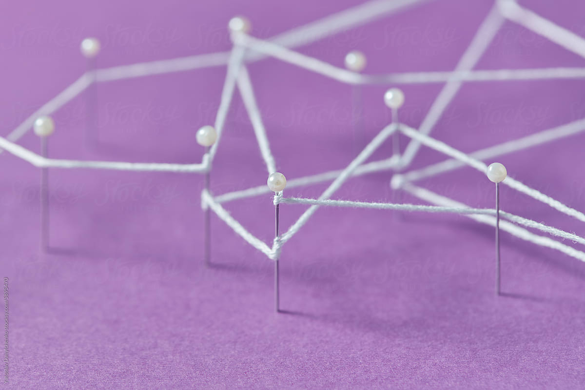 White thread tying chaotically stationery pins on violet background