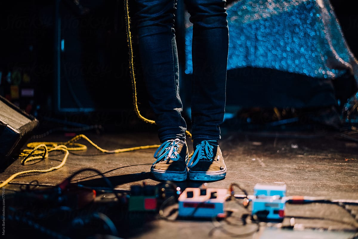 Feet on the stage near to the guitar pedals