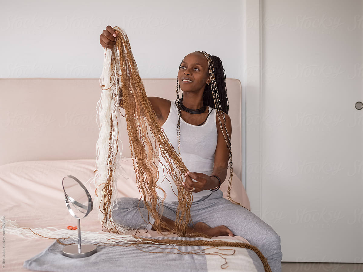 Excited woman preparing hair extensions for braiding