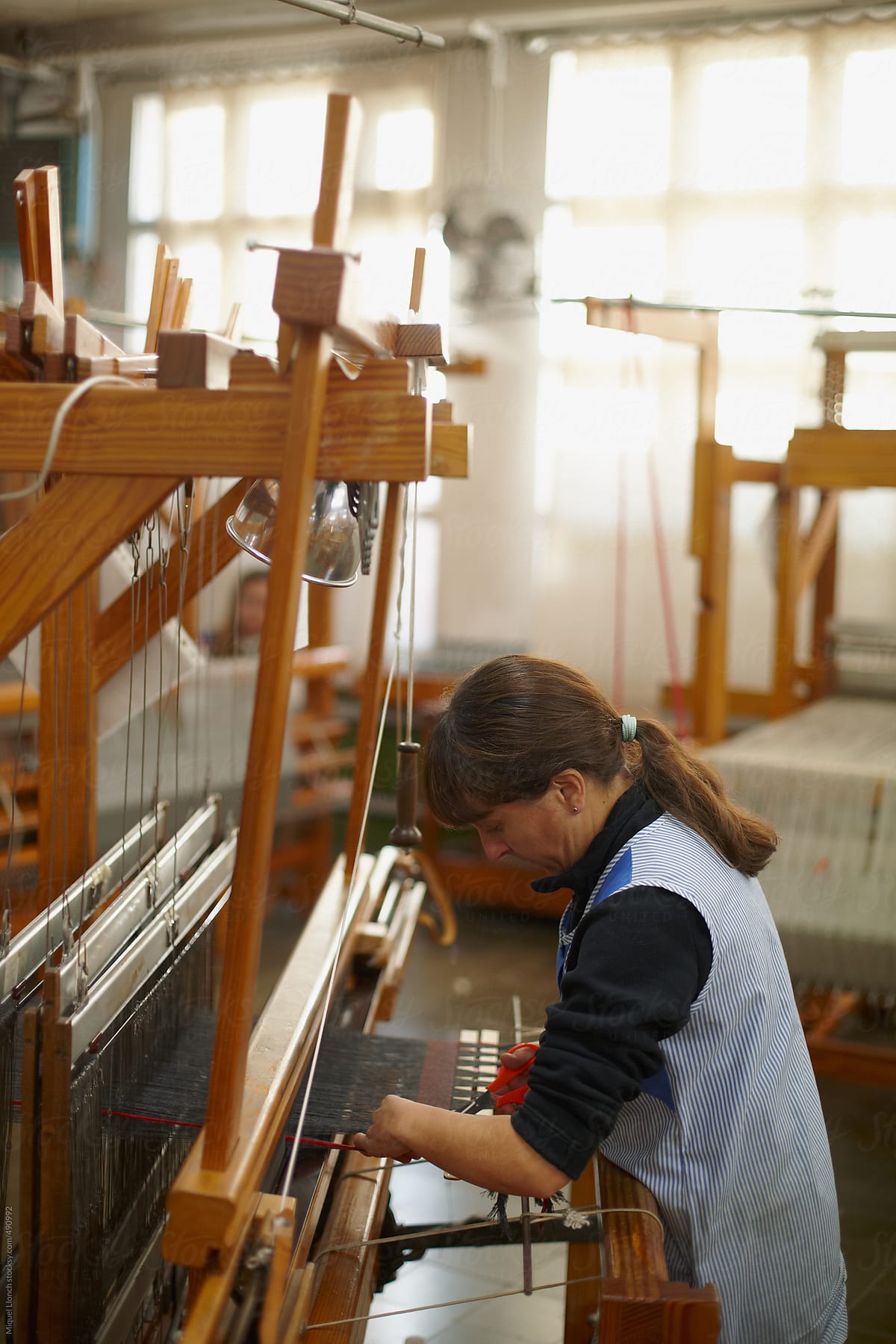 Woman weaver working with an artisanal loom in a workshop