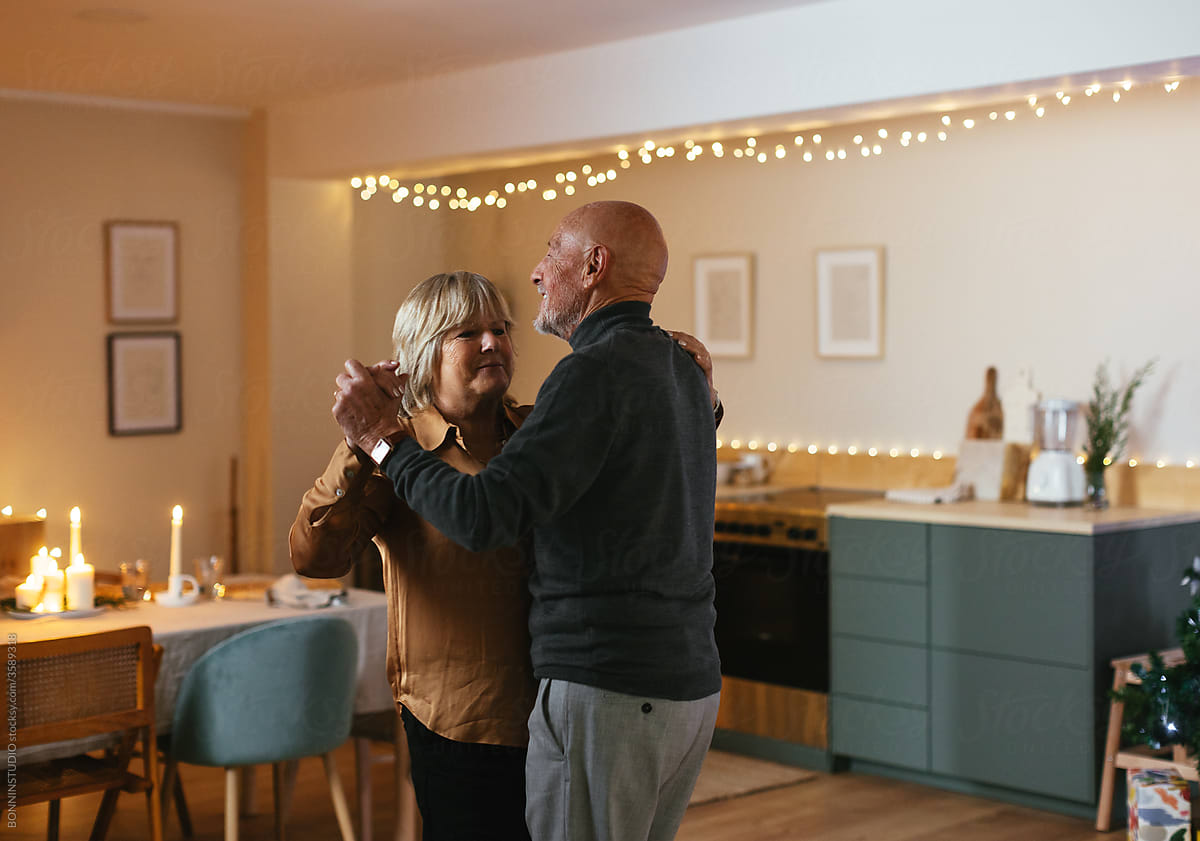 Loving senior couple dancing after Christmas dinner at home