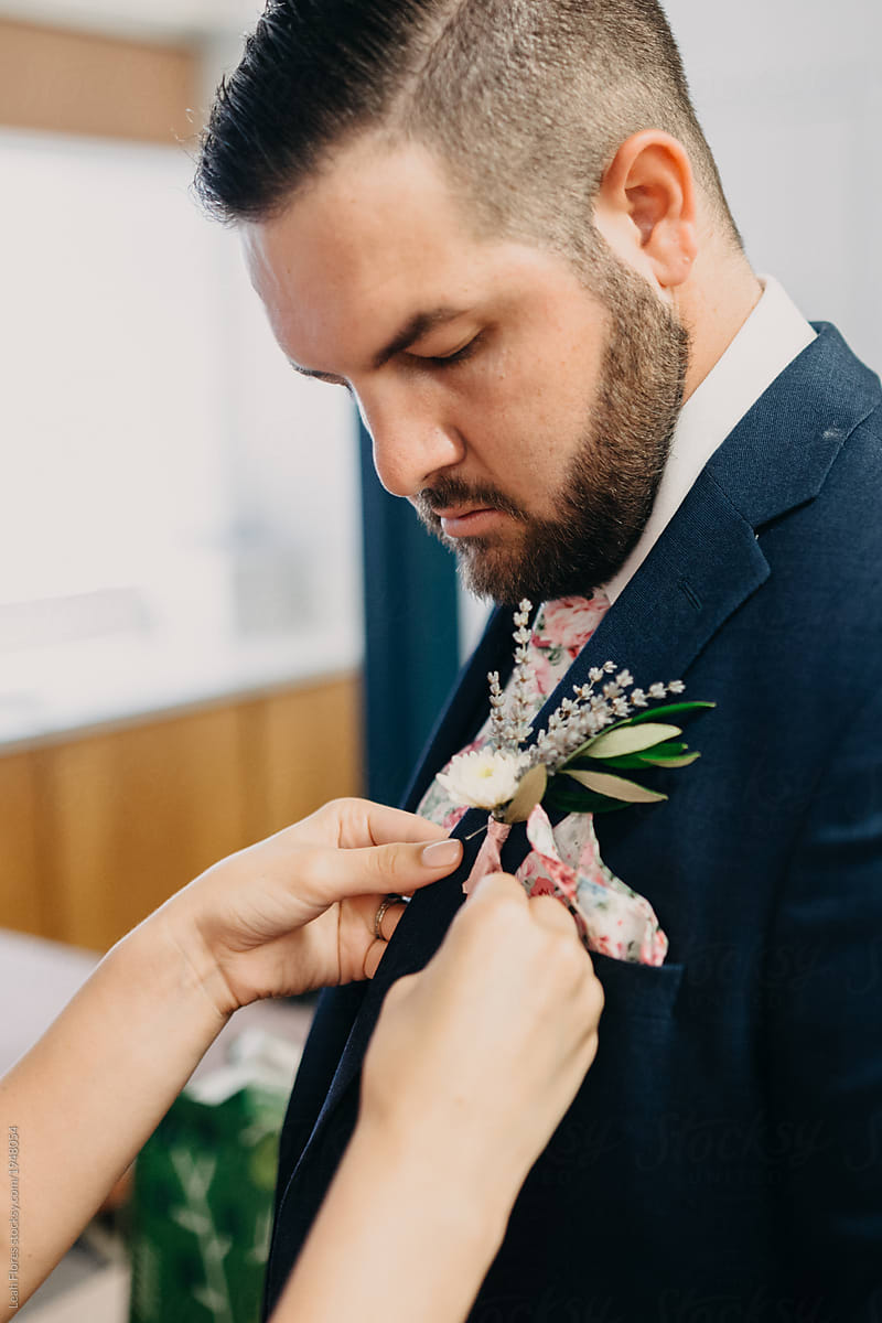 Groom Getting Boutonniere Pinned on Suit