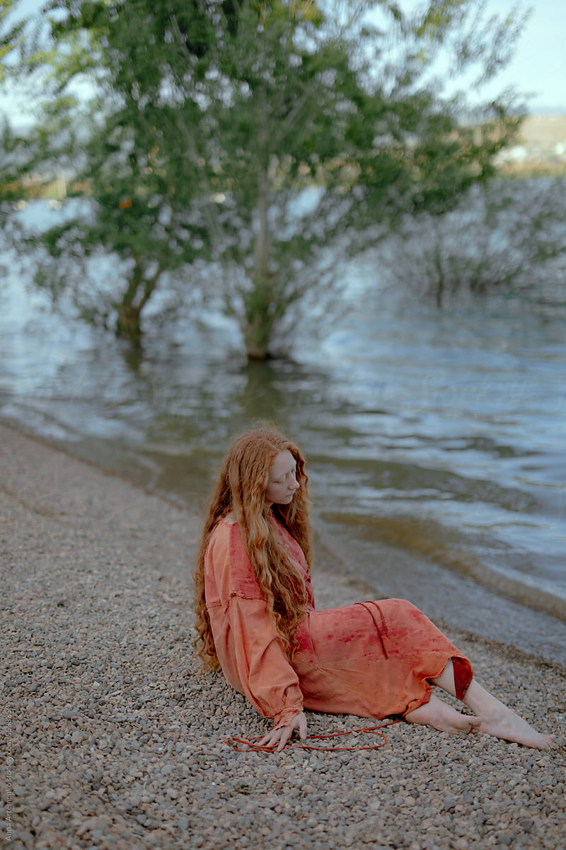 portrait of a red-haired woman near the water
