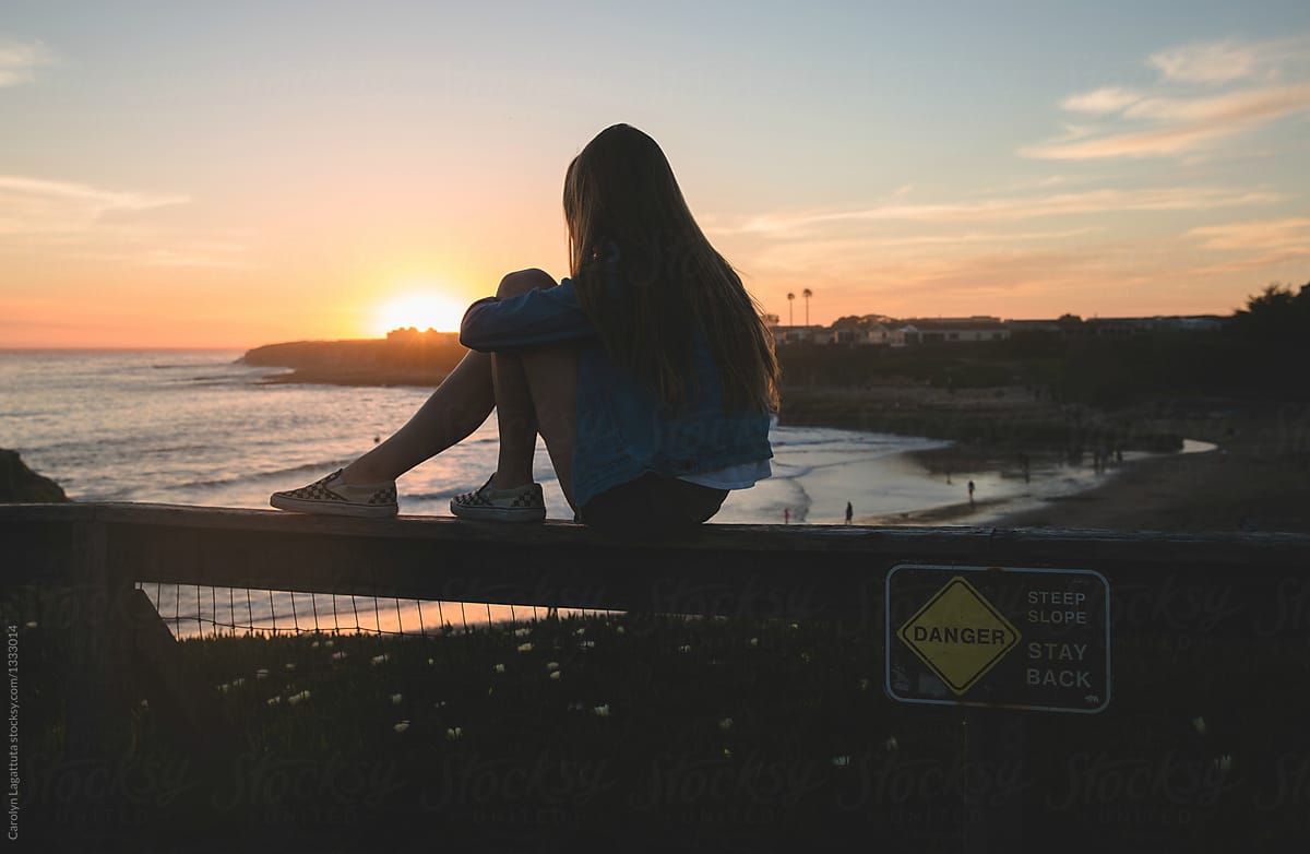 Teenage Girl Sitting On A Fence Watching The Sunset by Stocksy Contributor  Carolyn Lagattuta - Stocksy