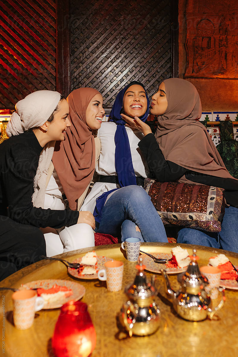 Group of diverse muslim friends sitting at tea house table