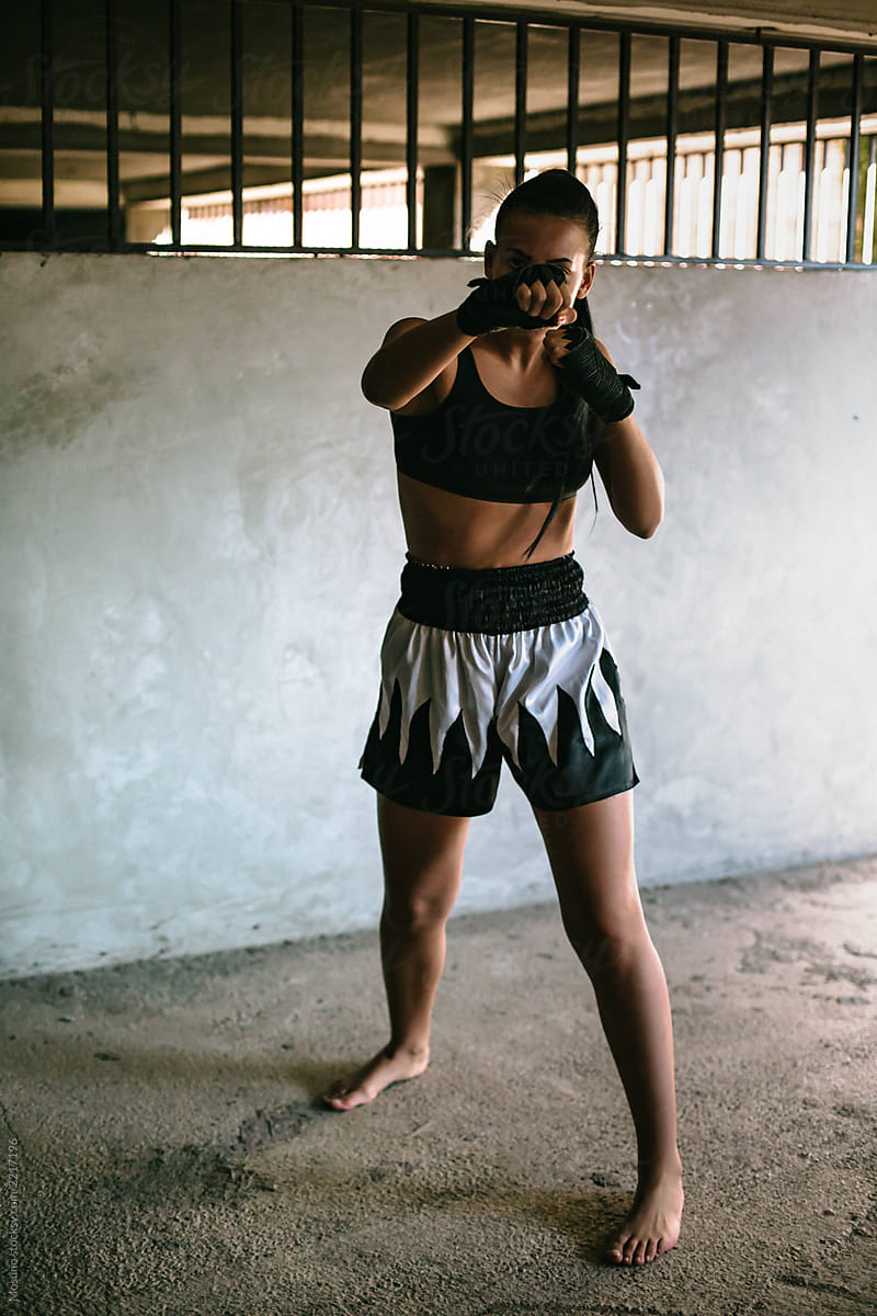 Kickboxing woman training in old gym