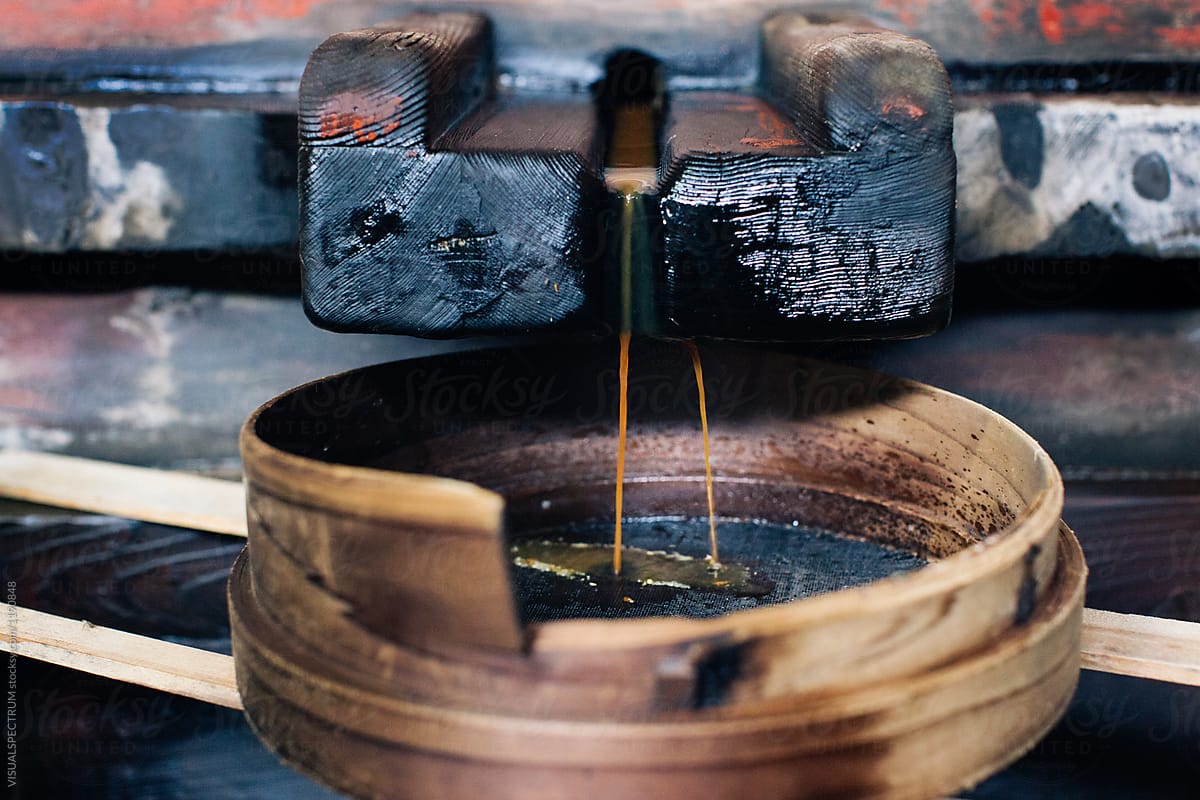 Closeup of Freshly Pressed Soy Sauce Dripping Through Wooden Strainer