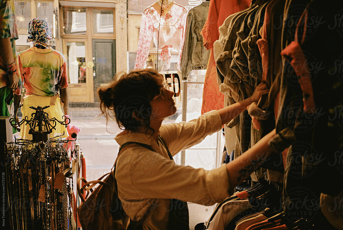 Woman choosing clothes in thrift shop