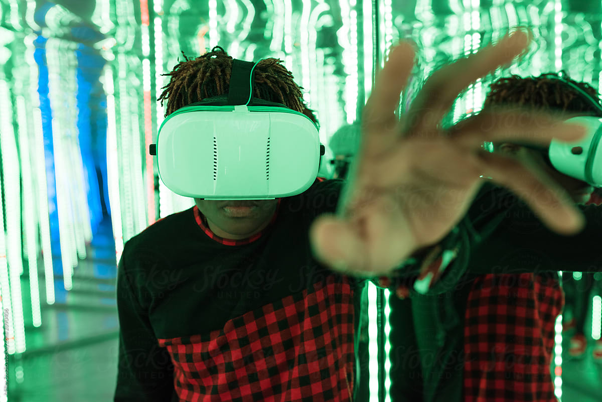 Ethnic youngster using VR glasses in maze