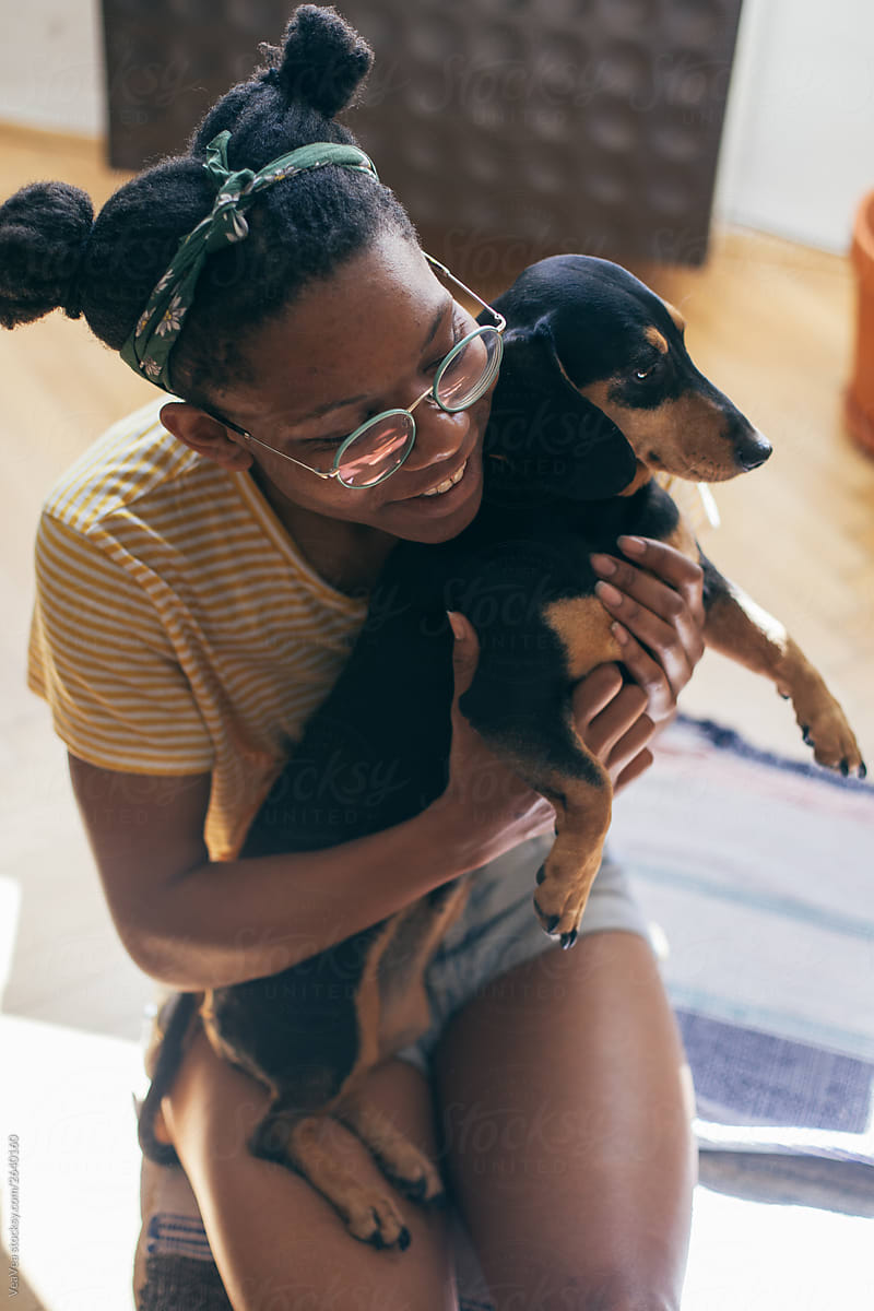 Woman spending time with her small black dog indoors