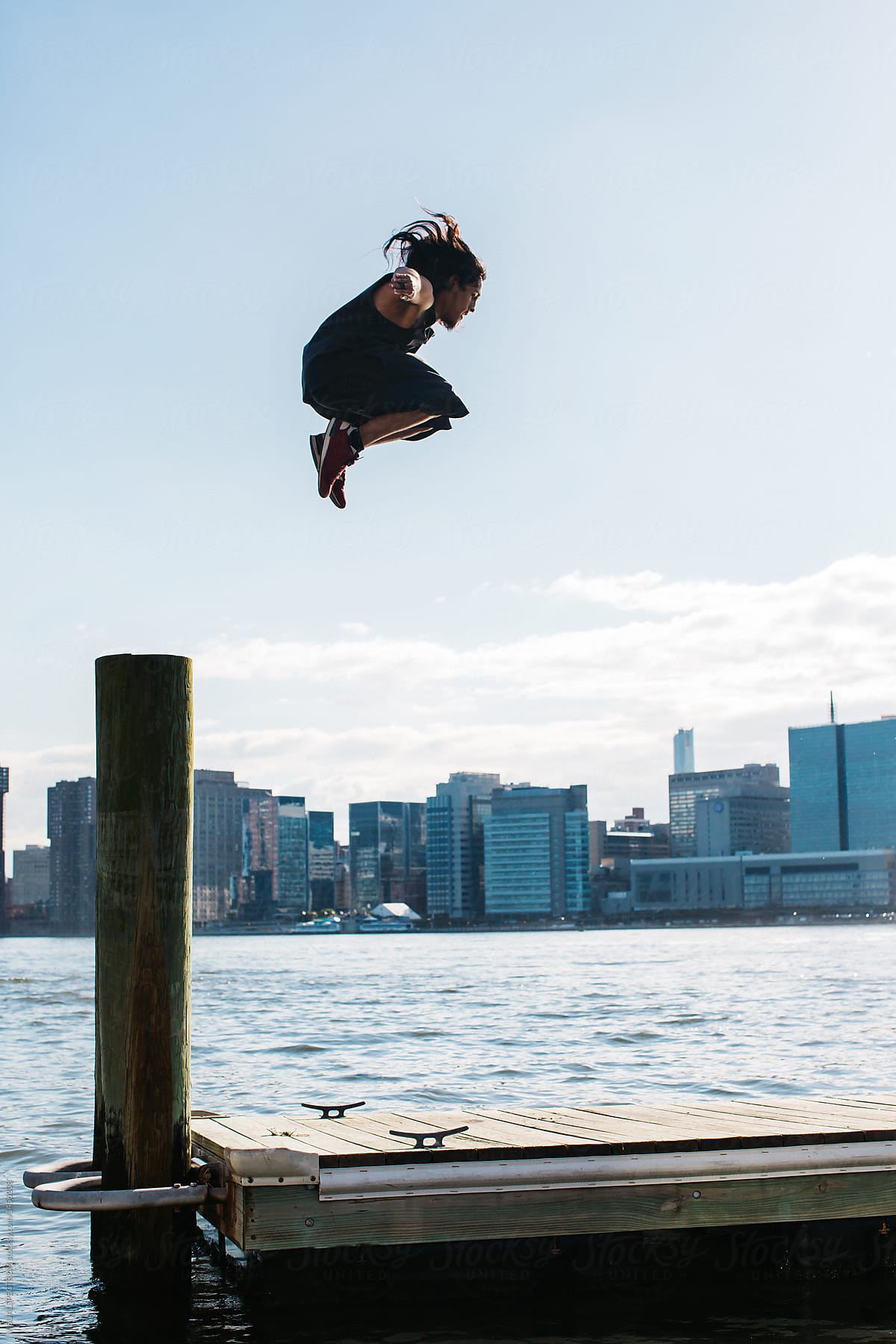 Parkour - Young Man Doing a High Jump From Wooden Pole