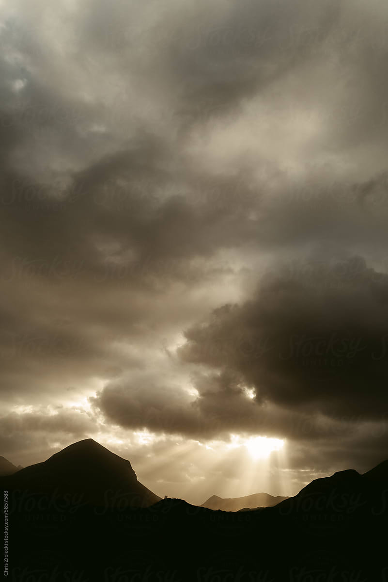 Sunset sky with dark clouds over mountains range