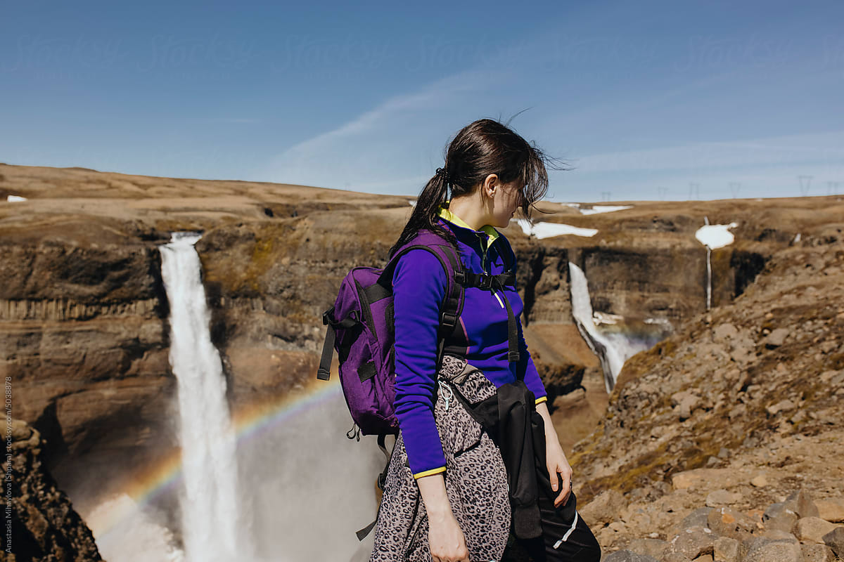 Traveler woman looking on A Huge Waterfall In Iceland with rainbow