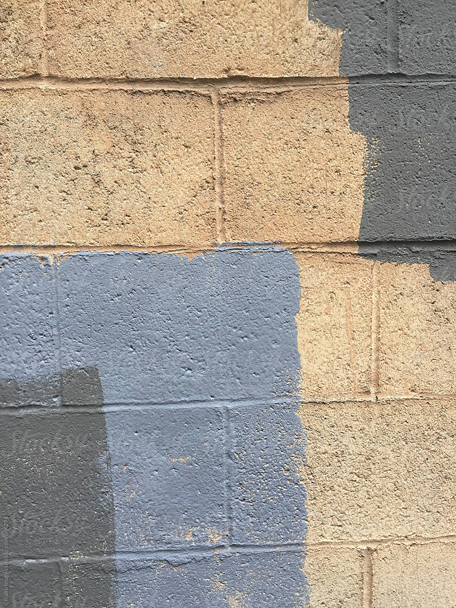 Paint covering graffiti tags on brick wall, close up