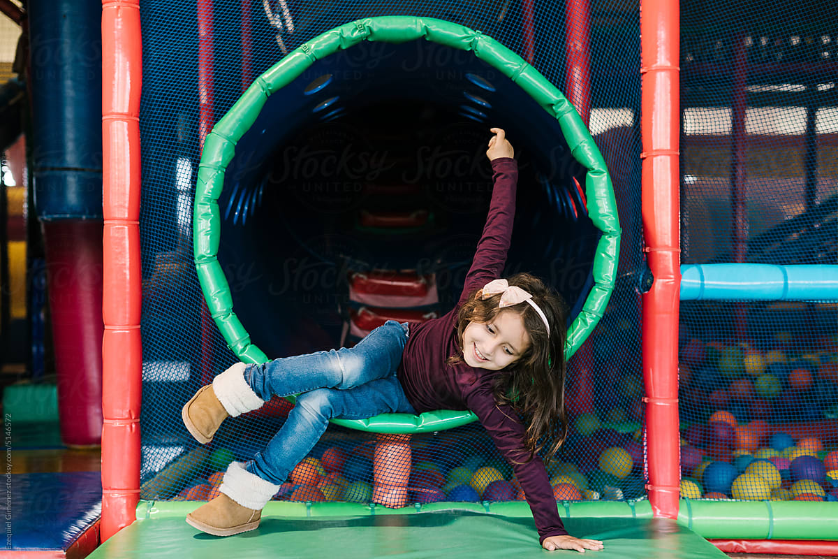 Joyful child falling on mat and smiling in playground