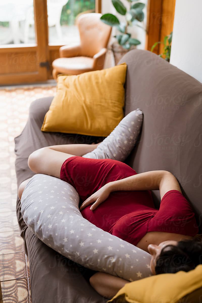 A pregnant woman sleeping on the sofa in the afternoon at home