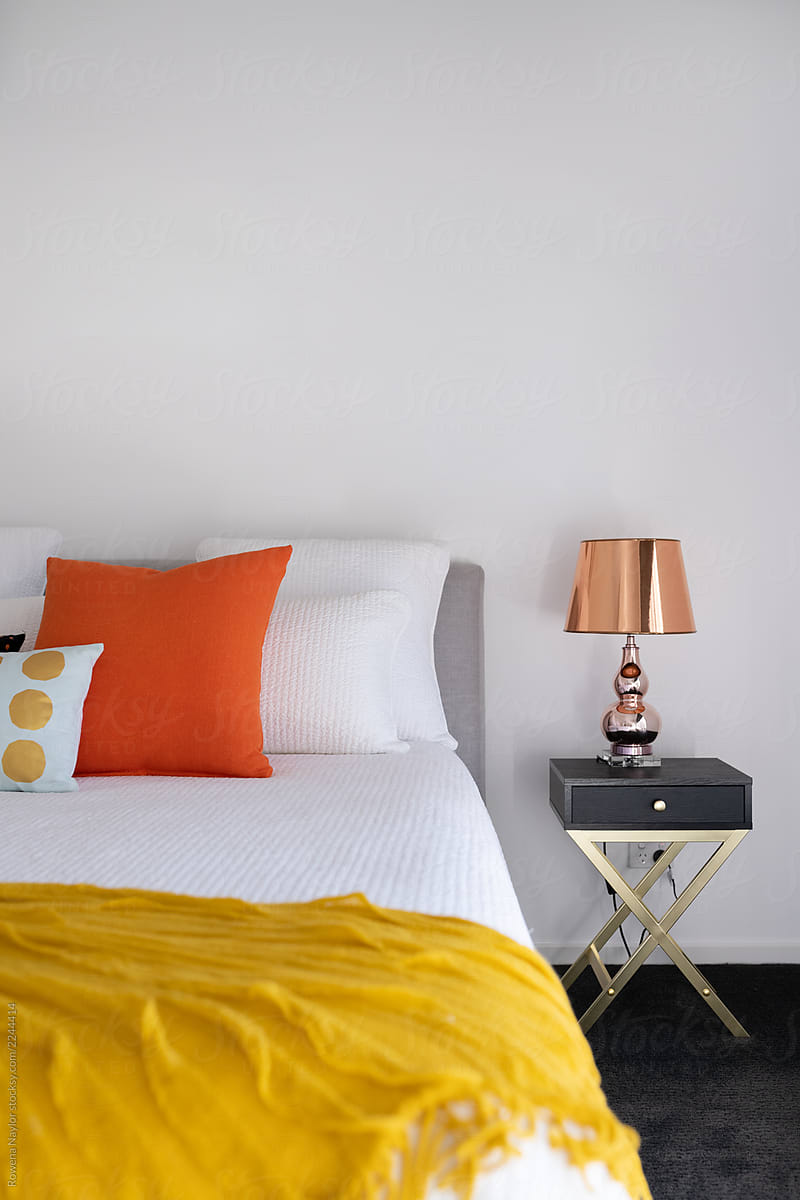Styled bedroom with mustard and orange accent colors