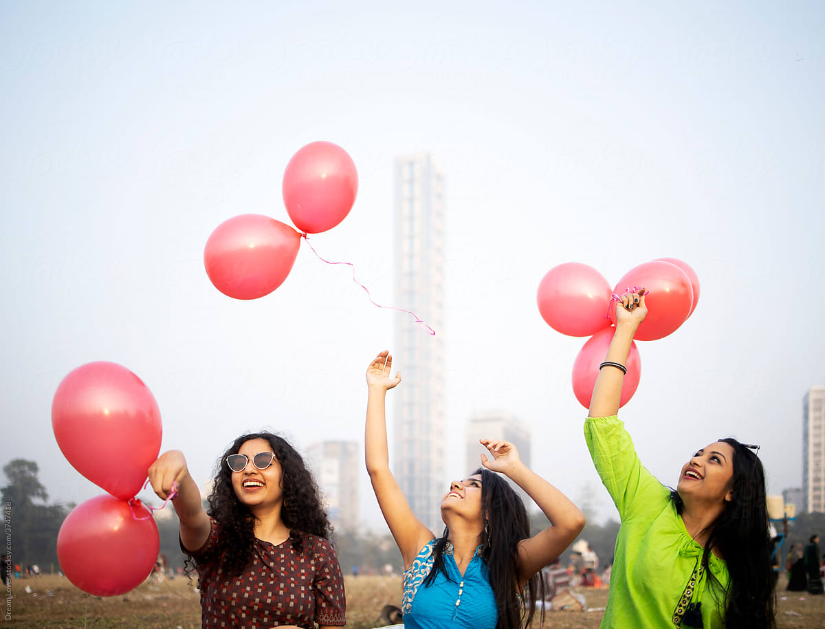Indian girls making fun with balloons at outdoors