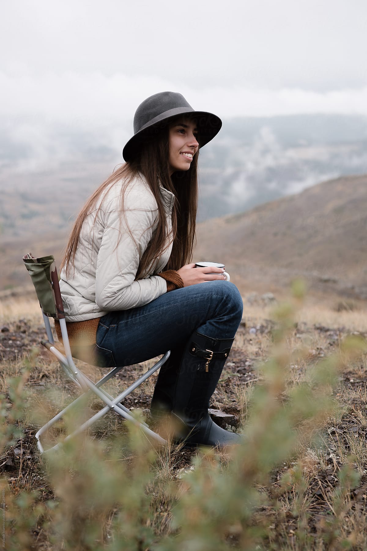 Girl with coffee posing in mountains