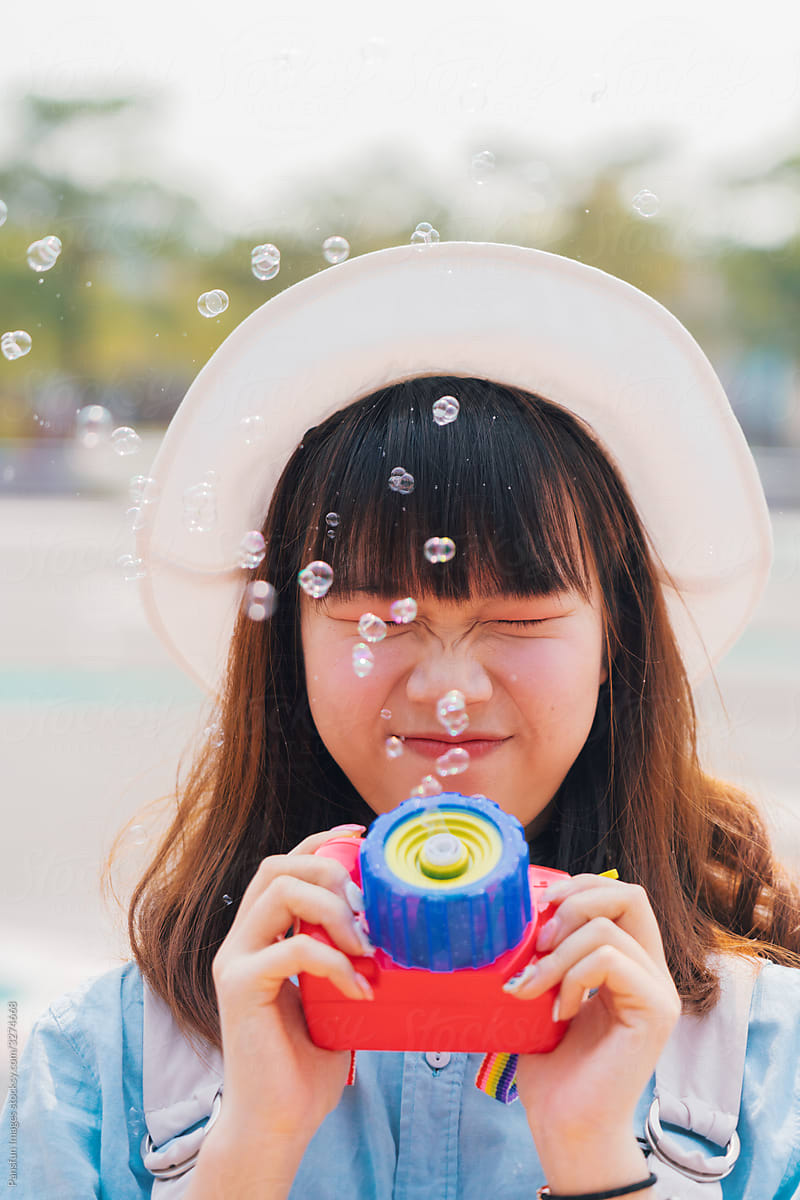 Young Asian women playing with camera bubble machine