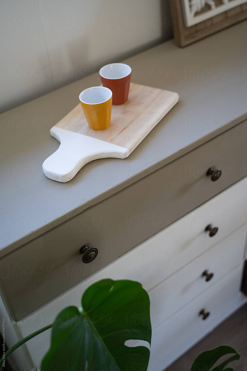 Detail of coffee cups on top of drawer at home