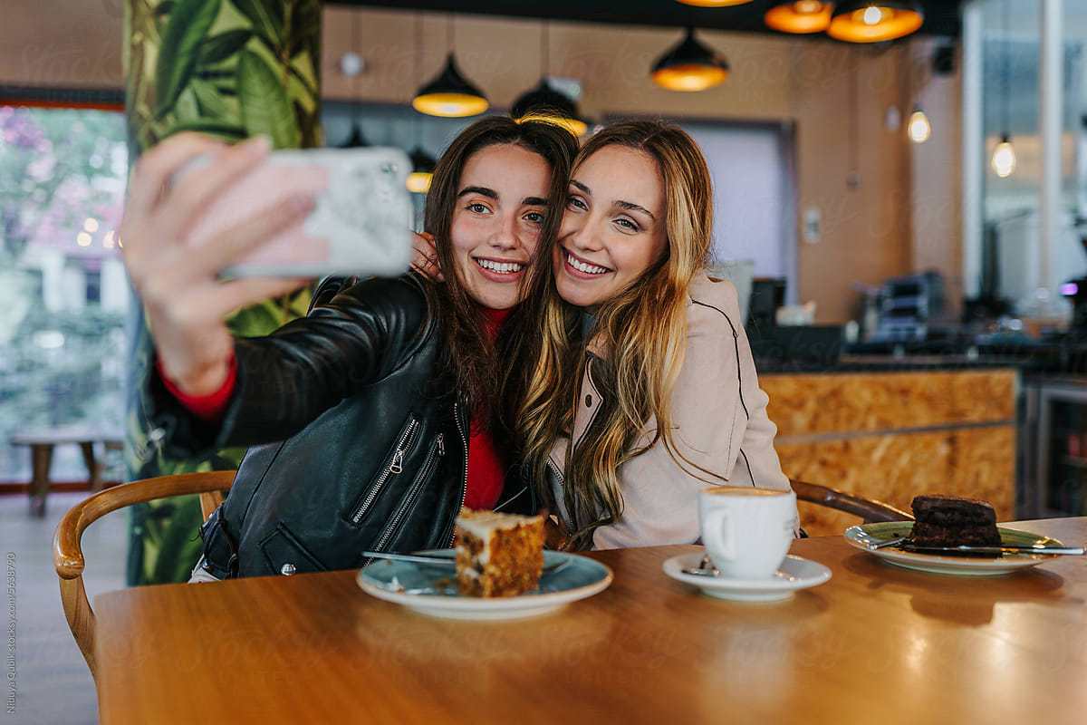 good friends taking a selfie at a coffee shop