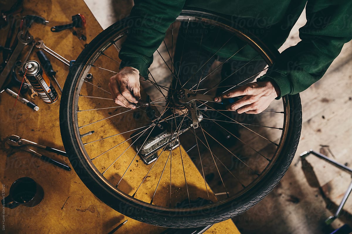High angle shot of hands fixing bicycle wheel