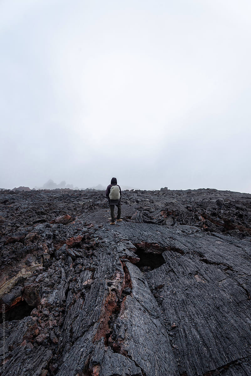 Man walks by black magma fields of Tolbachic volcano, Kamchatka Russia.