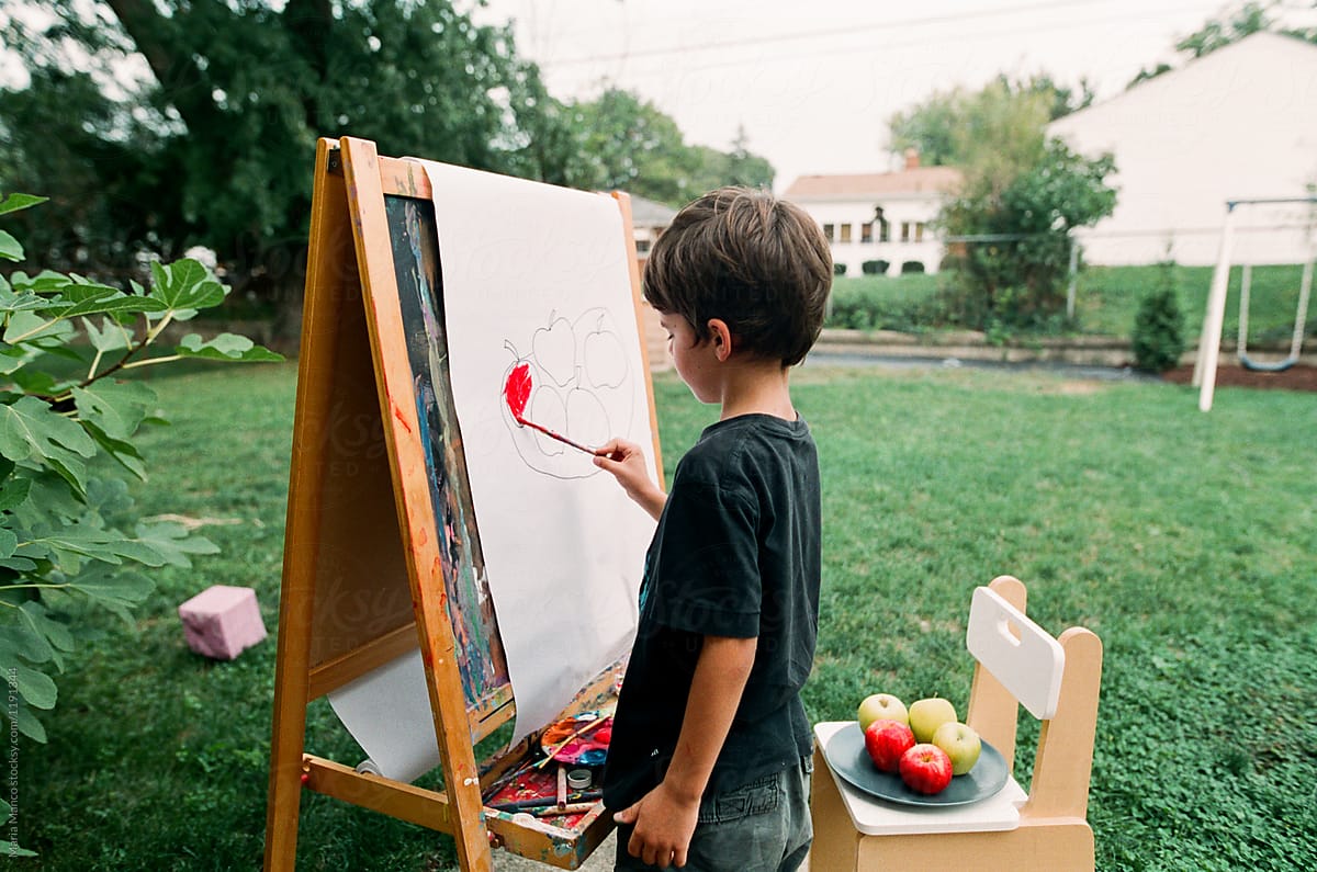 child painting on easle outside