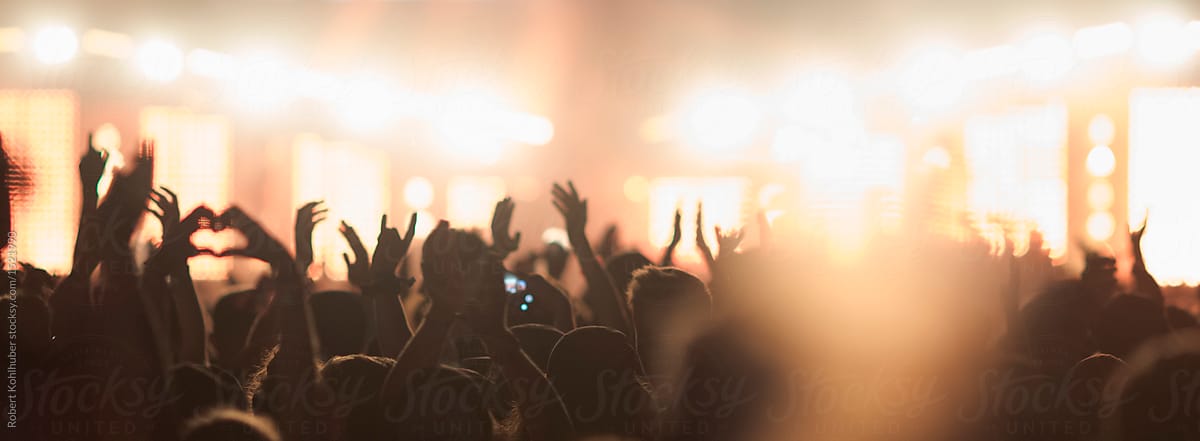 Sillhouettes of concert crowd in front of bright stage lights