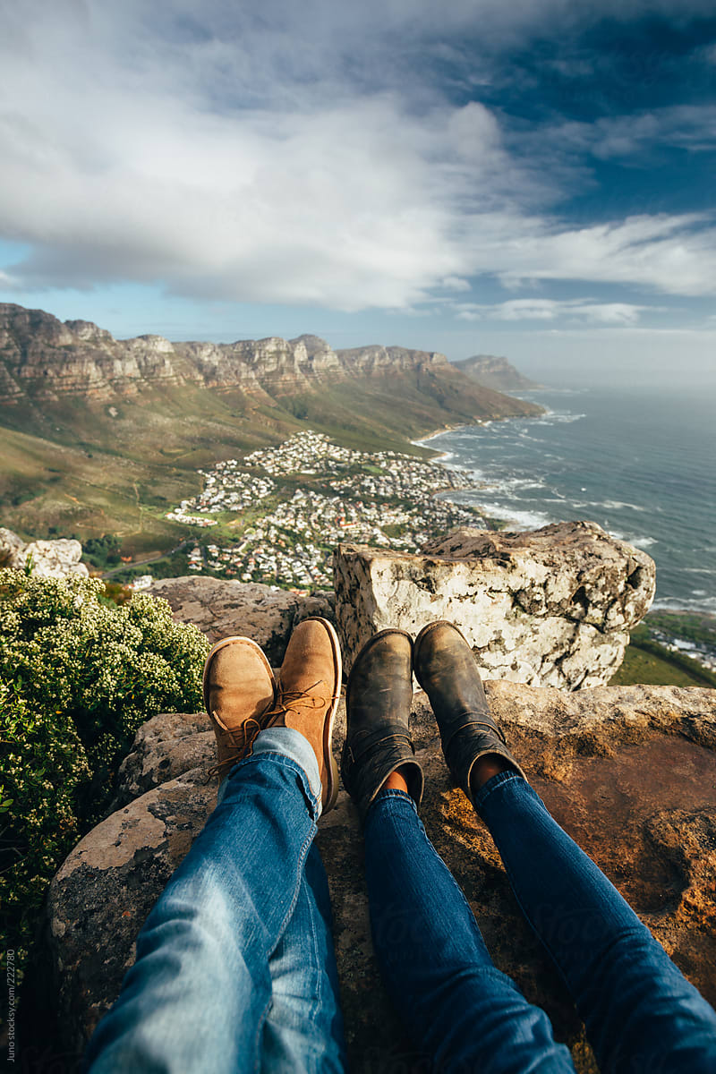 leather shoes and jeans of a relaxed hiking couple sitting at a mountain top