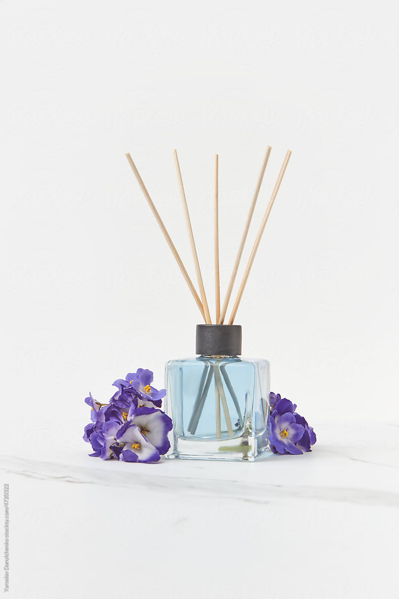 Glass aroma diffuser with violet flowers.