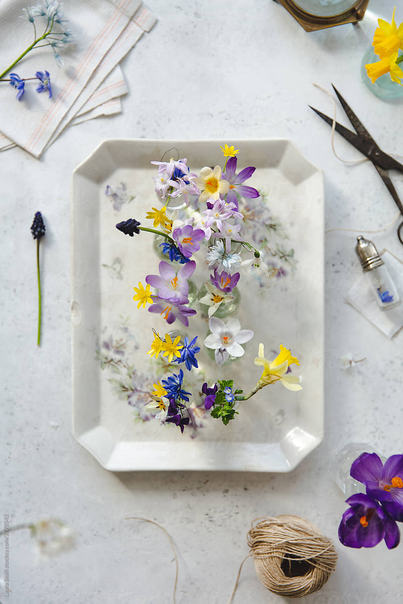 Arranging flowers in jars on porcelain tray