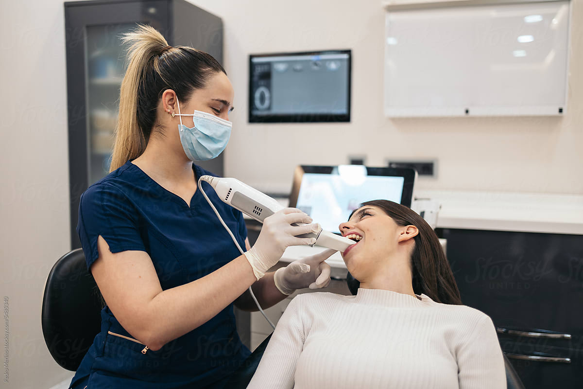 Dentist using an intraoral scanner with a patient in the clinic
