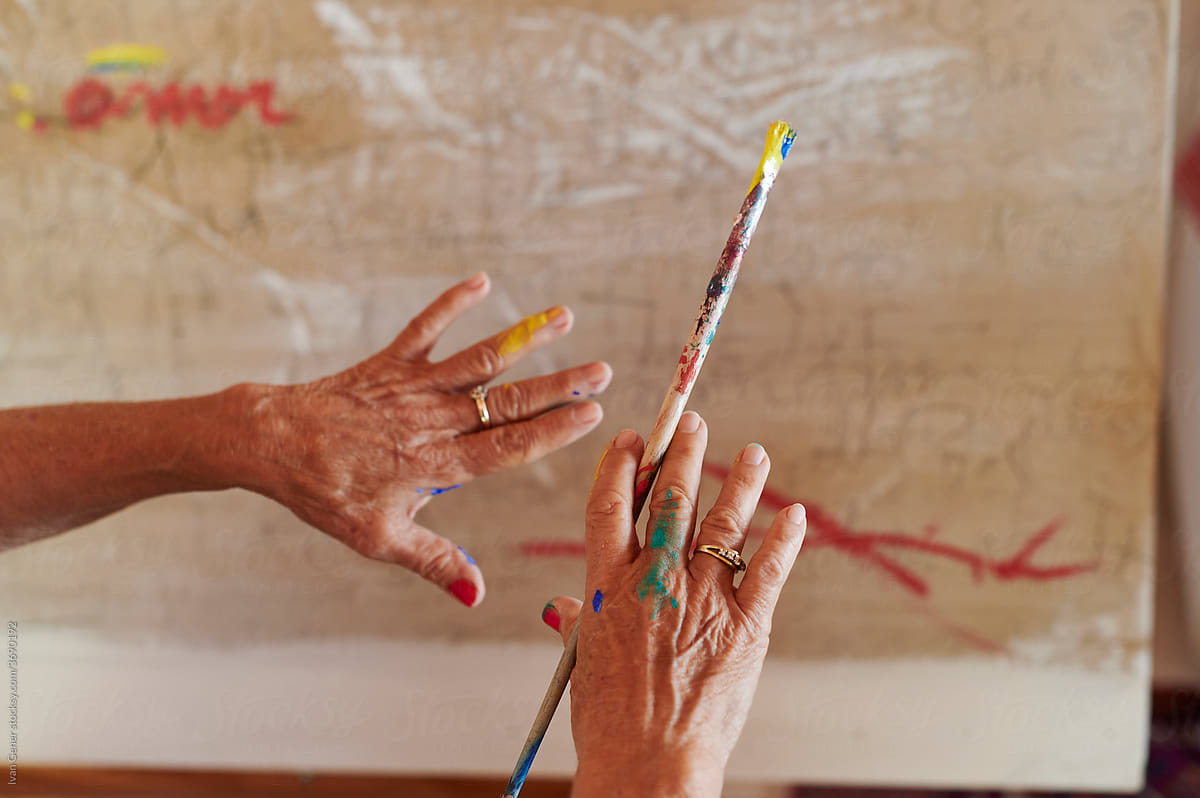 Senior woman holding a paintbrush in her studio