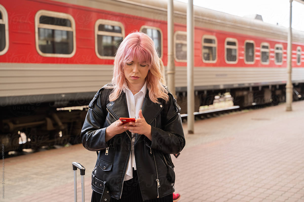 Woman Using Smartphone At Train Station