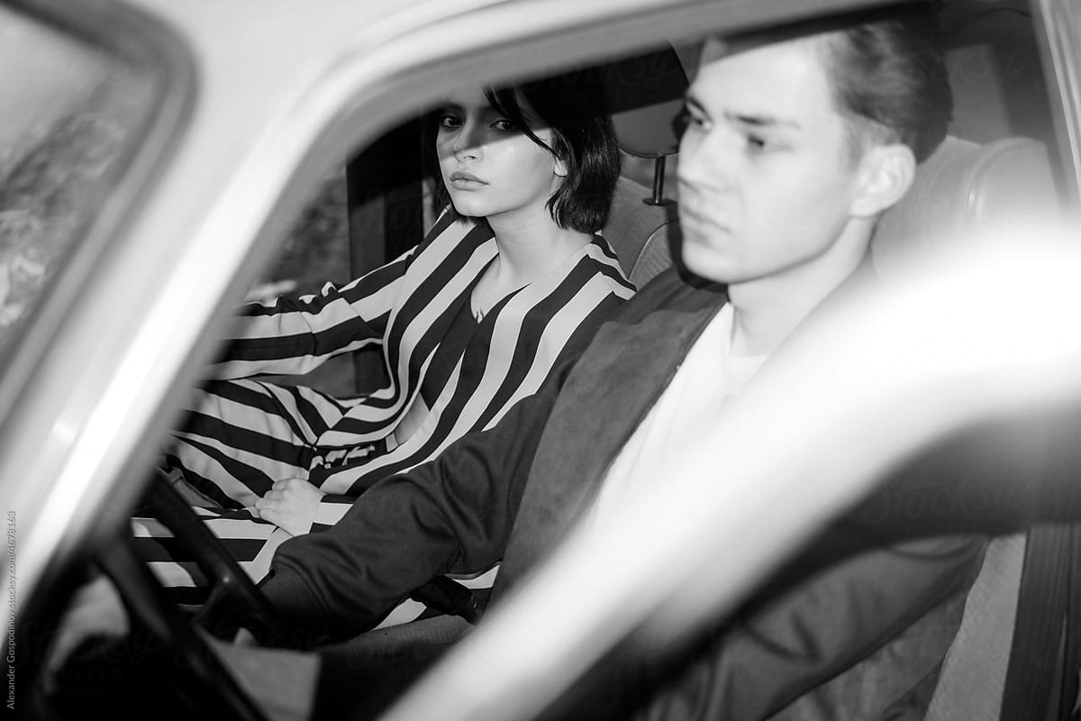 A stylish couple inside a car