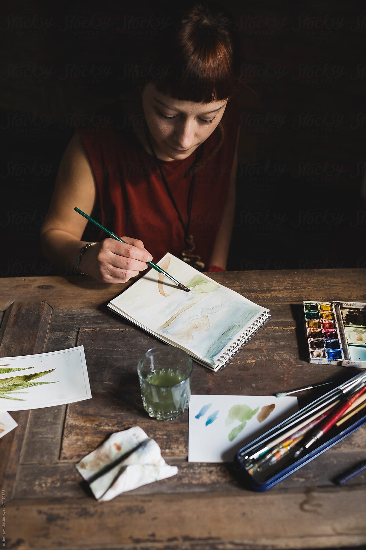 Young woman painting with watercolors in her studio