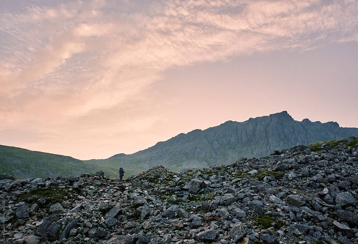 Female walker at sunrise climbing up to Scafell Pike from Wasdale.