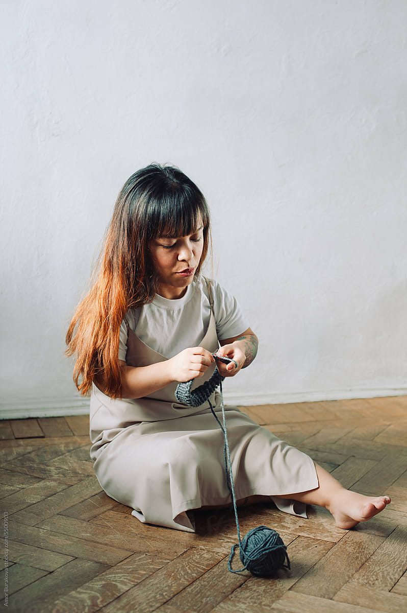 Young dwarf woman knitting