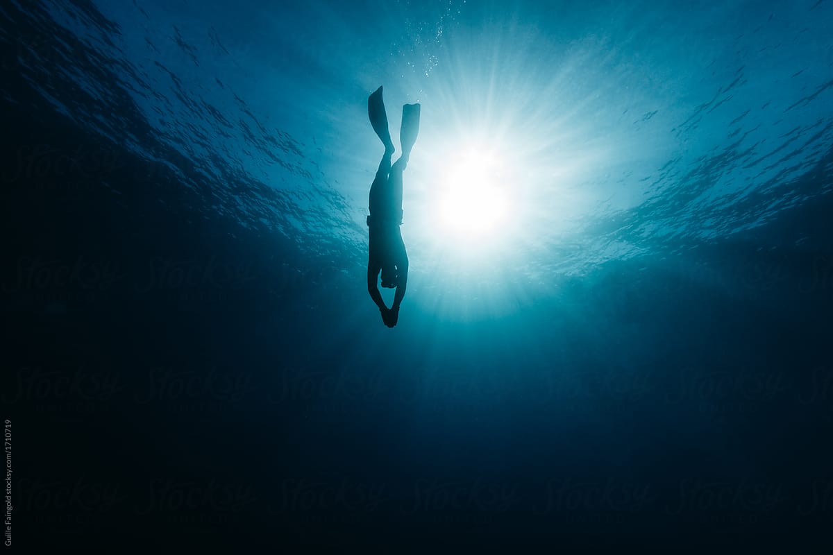 Black silhouette of freediver underwater
