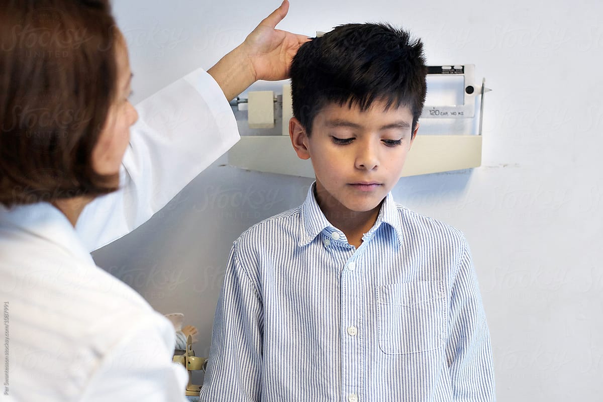 Doctor checks weight of young boy
