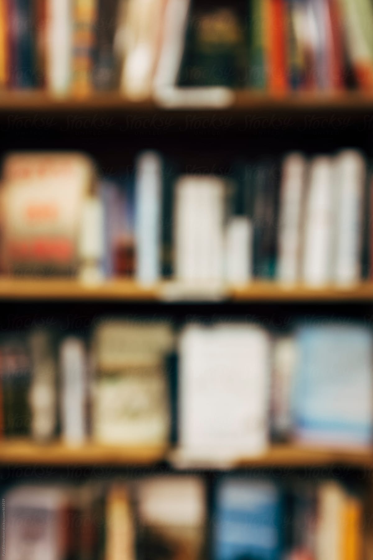 Row of books on bookshelves, blurred focus