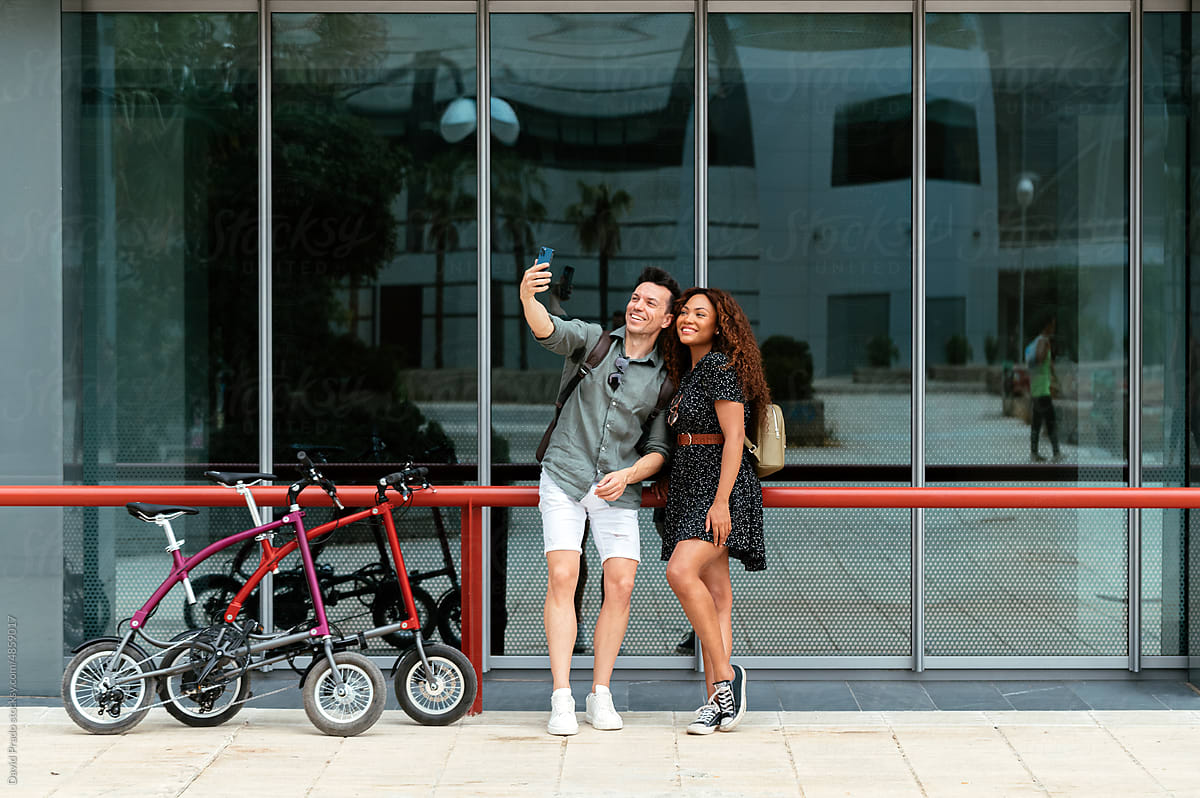 Multiracial bicyclists taking selfie on street