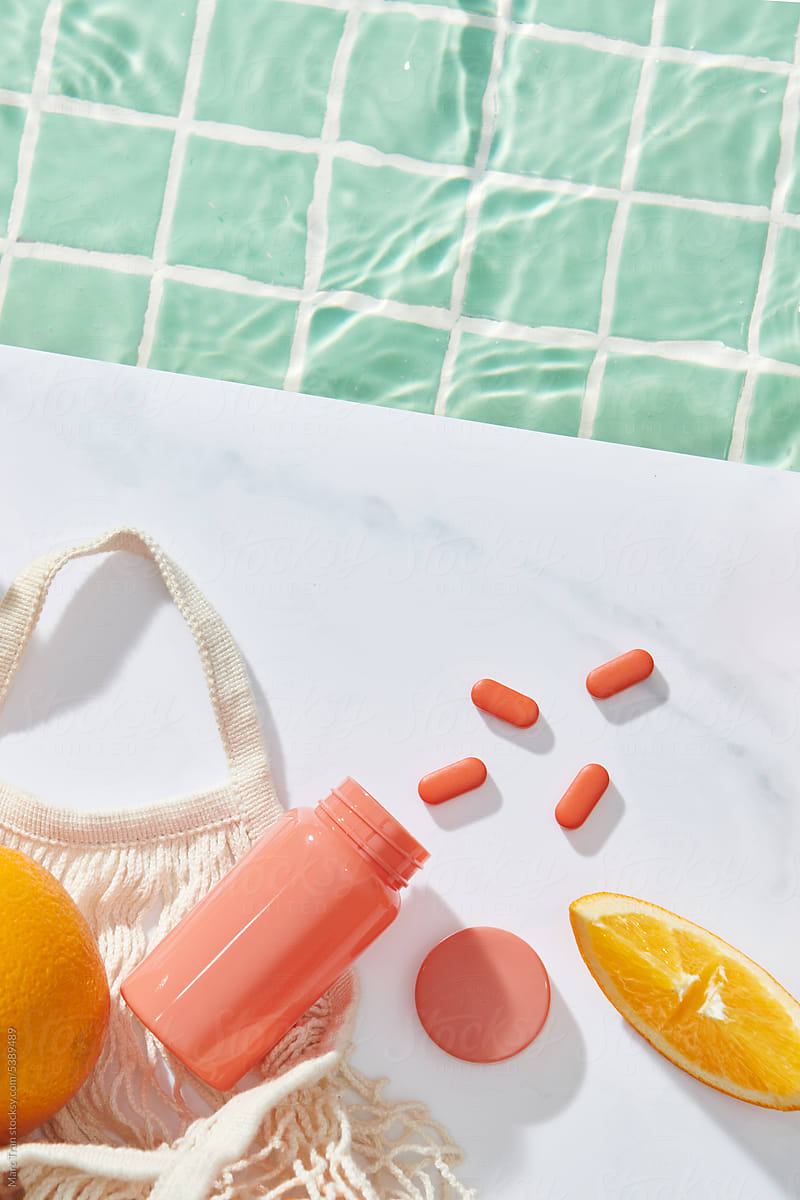 Vitamin Bottle with vitamin C pills and oranges