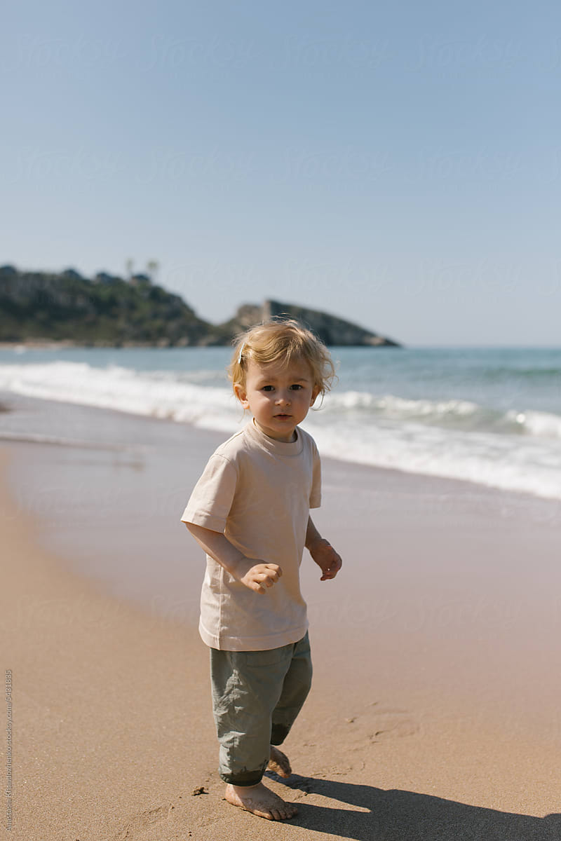 Child looking at camera in front of the sea