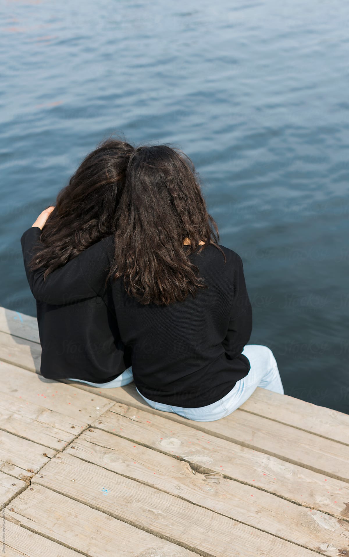 two sisters sitting by the sea