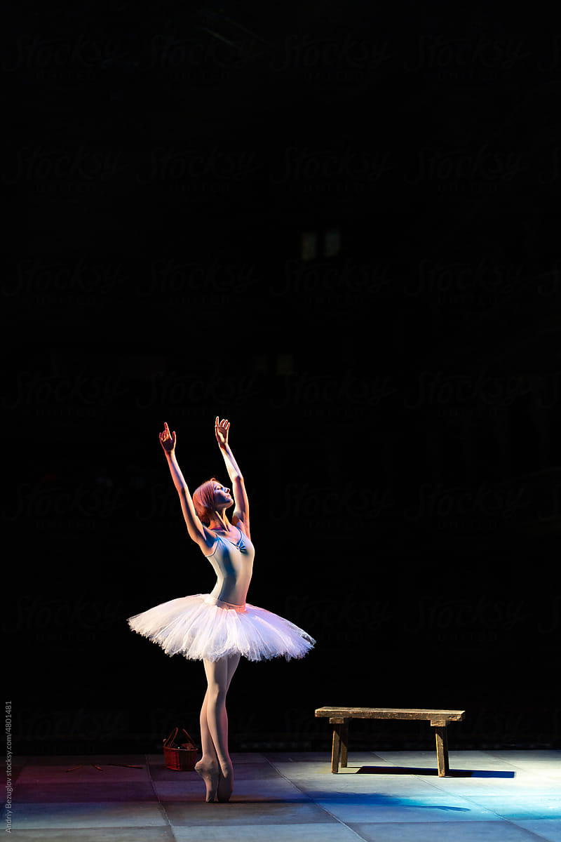 Fit girl ballerina stands in white ballet tutu like white swan