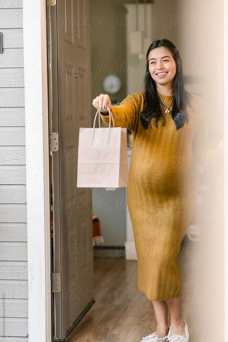 Advanced pregnant woman doing shopping bag delivery