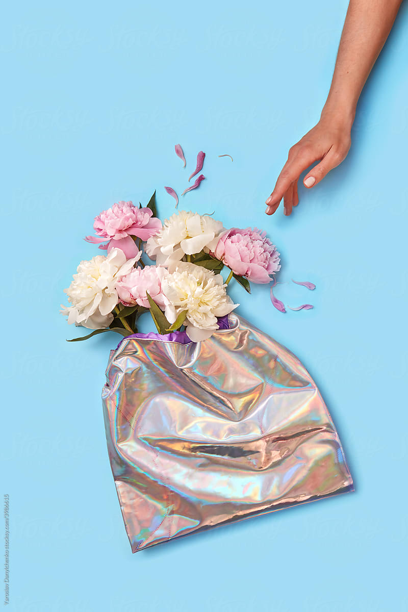 Girl touching peonies in holographic foil bag